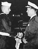 1965-graduation 23-year-old Fred Young in uniform shaking hands at his US Navy training graduation.