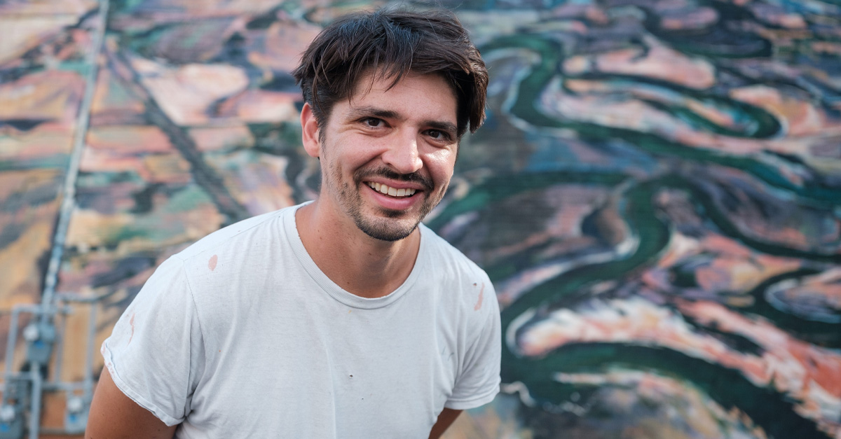 Thomas Agran in front of his mural